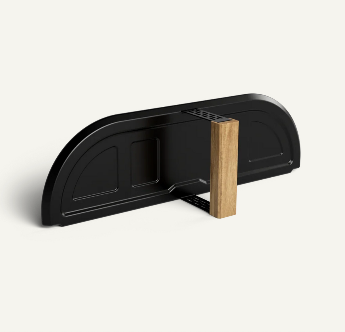 A modern black wall-mounted shelf or rack with a curved back panel and a single vertical wooden support block, shown on a clean off-white background.